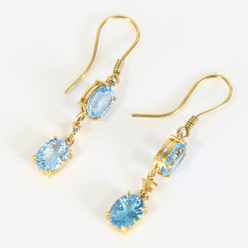 88 - A pair of modern handmade 18ct gold blue topaz and diamond drop earrings, set with oval mixed cut to... 