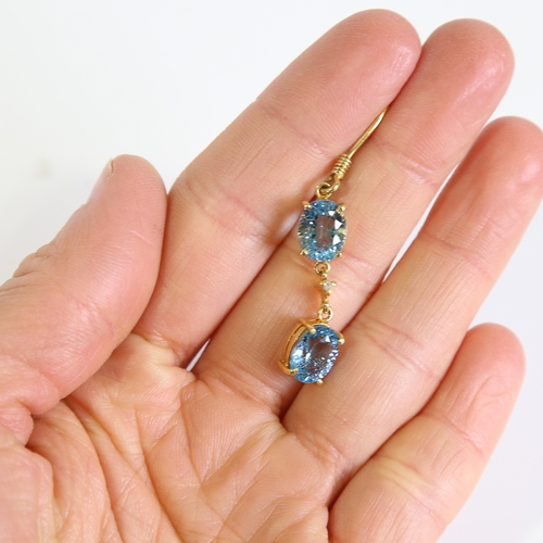 88 - A pair of modern handmade 18ct gold blue topaz and diamond drop earrings, set with oval mixed cut to... 