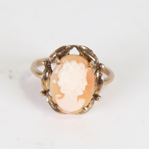 115 - A late 20th century cameo ring, unmarked gold settings with central relief carved shell depicting a ... 