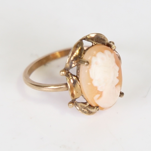 115 - A late 20th century cameo ring, unmarked gold settings with central relief carved shell depicting a ... 