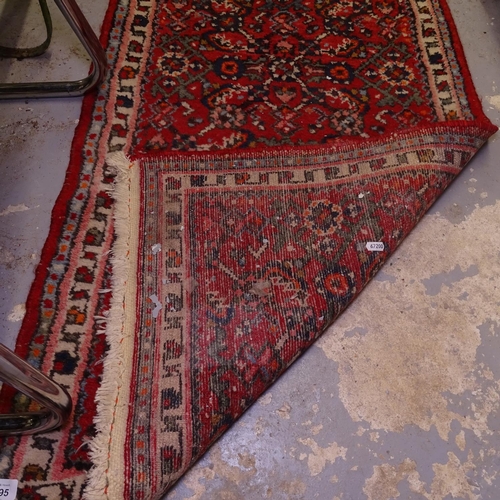 1995 - A red ground Caucasian design runner, 203cm x 68cm