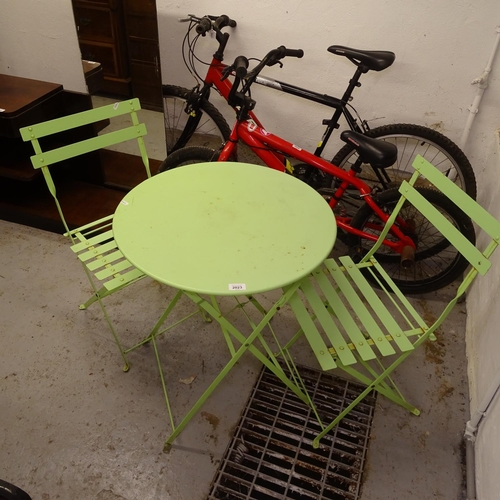 2023 - A green painted metal circular folding garden table, together with a pair of matching folding chairs