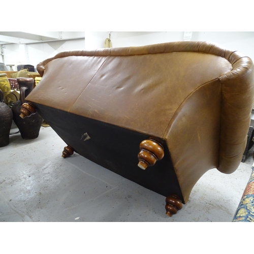 2089 - A buttoned brown leather upholstered Chesterfield settee with rollover arms, on turned stained wood ... 