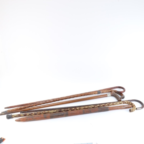 534 - A Tribal hardwood club with painted animals, length 81cm, and a group of Vintage walking canes (6)