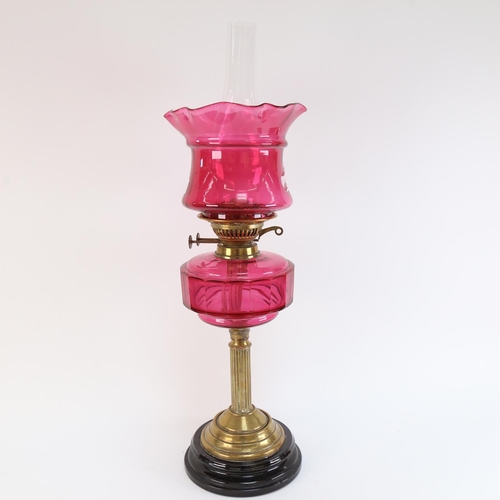 552 - A Victorian cranberry glass and brass-mounted oil lamp, with cranberry shade, overall height 64cm (A... 