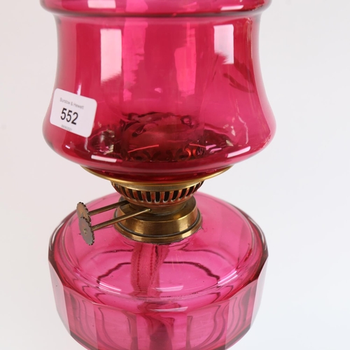 552 - A Victorian cranberry glass and brass-mounted oil lamp, with cranberry shade, overall height 64cm (A... 