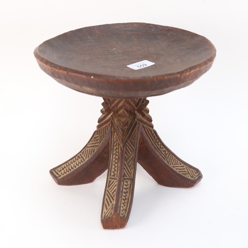 559 - A Tribal carved hardwood stool, carved from one piece of wood, height 25cm, diameter 25cm