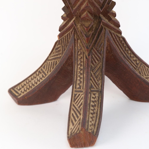 559 - A Tribal carved hardwood stool, carved from one piece of wood, height 25cm, diameter 25cm