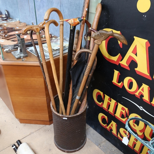 655 - A collection of walking sticks, in Vintage stand