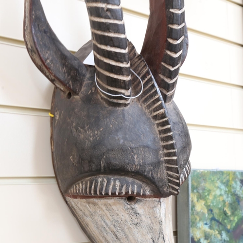 659 - A carved and painted Tribal wall mask, modelled as the head of a antelope, height 70cm