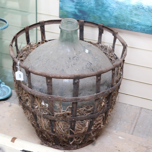 660 - A large green glass carboy, in original metal container, diameter 51cm