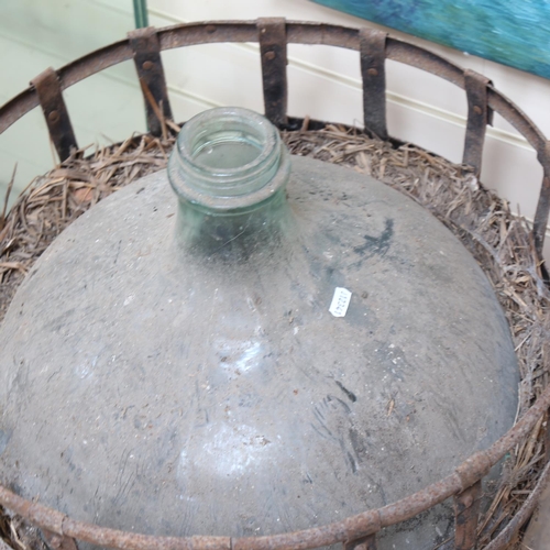 660 - A large green glass carboy, in original metal container, diameter 51cm