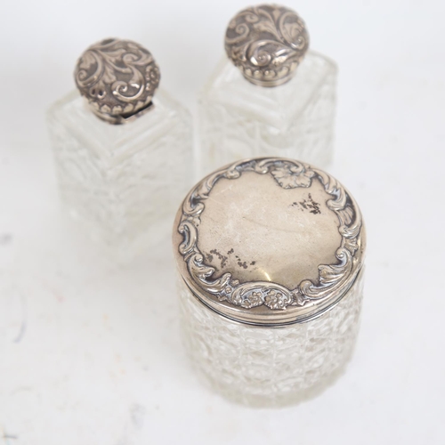 939 - 3 cut-glass and embossed silver-mounted scent bottles, and a silver-topped dressing table jar