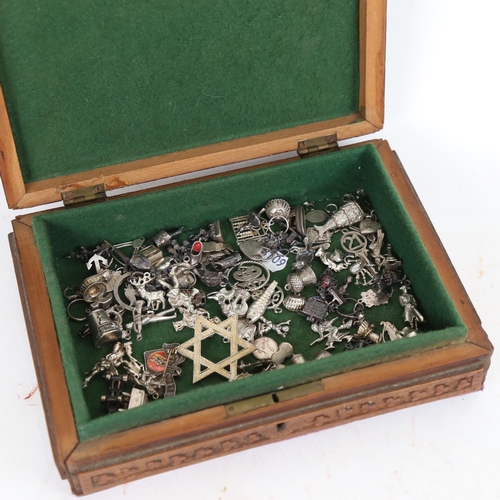 947 - A collection of silver charms and brooches, in an Anglo-Indian carved box