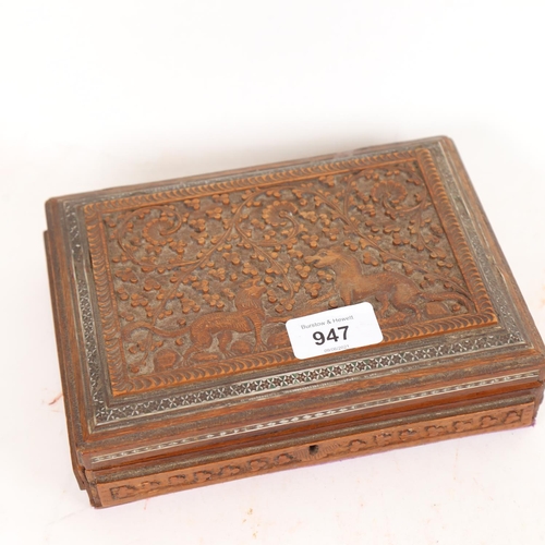 947 - A collection of silver charms and brooches, in an Anglo-Indian carved box