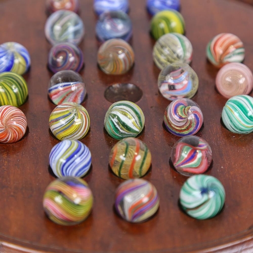 133 - A 19th century turned wood solitaire board and marbles, including onion skins, diameter 26cm