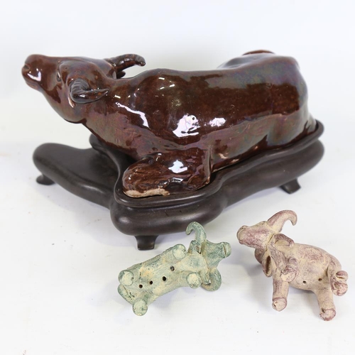 171 - A Chinese brown treacle glaze pottery buffalo on hardwood stand, length 21cm, and 2 miniature potter... 