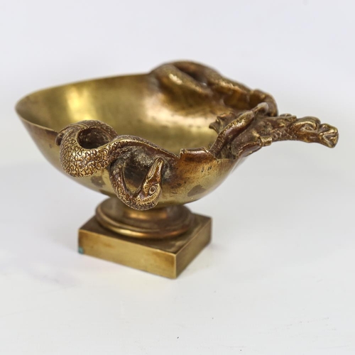 210 - A polished bronze bowl on stand, relief cast serpent and mask designs, length 18cm