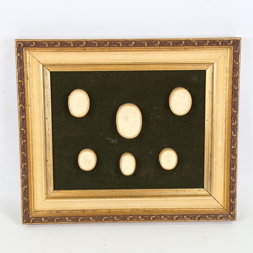 215 - A framed set of plaster cameo and intaglio plaques, frame 29cm x 34cm