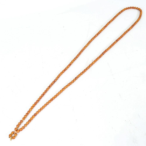 242 - A string of honey coloured natural horn beads, possibly rhino horn