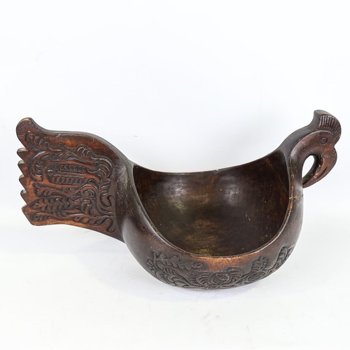 254 - A large Russian carved and stained wood bowl, in the style of a Kovsh, length 48cm