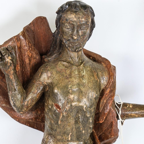 273 - A carved and painted wood religious figure carrying a pennant, probably 18th century, height 57cm