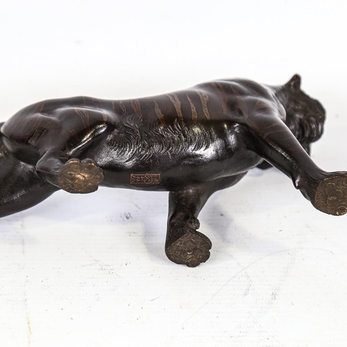 303 - A Japanese patinated bronze striped tiger, seal mark under base, length 24cm