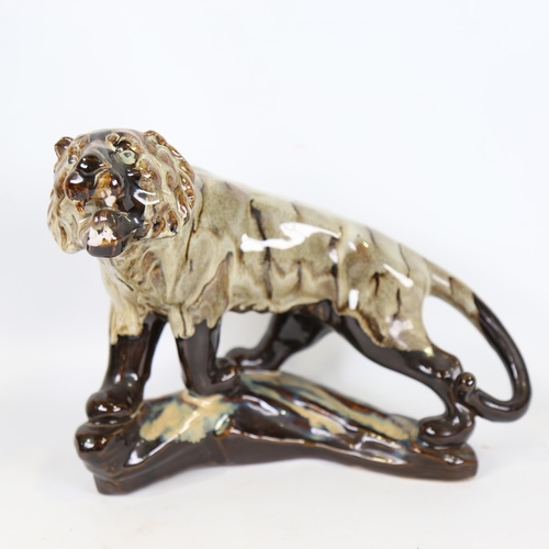 69 - A Chinese treacle glaze ceramic tiger, 20th century, length 30cm, together with a blue and white por... 