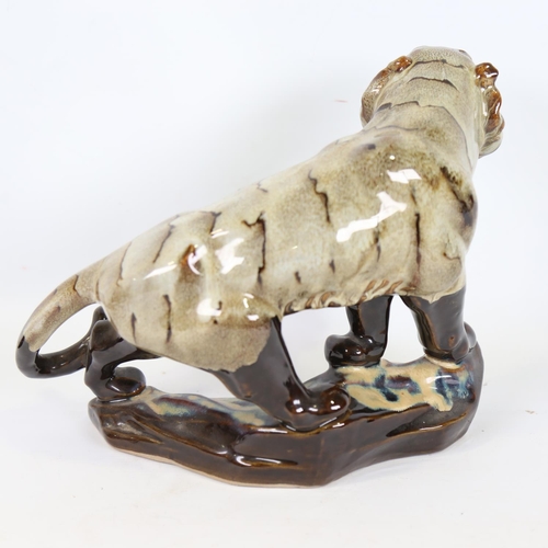 69 - A Chinese treacle glaze ceramic tiger, 20th century, length 30cm, together with a blue and white por... 