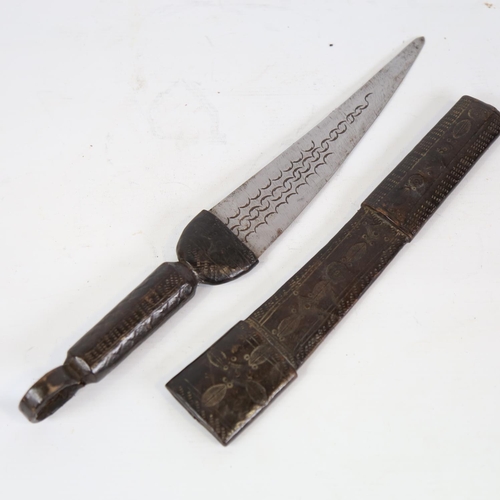 81 - An African hunting knife, with embossed leather scabbard and handle, overall length 44cm