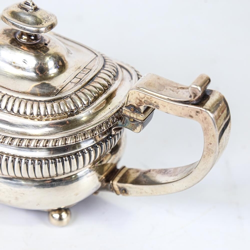 586 - A Georgian silver teapot, oval bulbous form with fluted decoration and gadrooned rim, with ivory ins... 