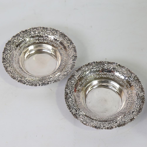 588 - A pair of early 20th century silver bon bon baskets, relief embossed floral border with pierced fret... 