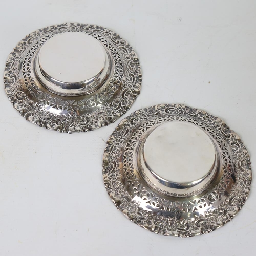 588 - A pair of early 20th century silver bon bon baskets, relief embossed floral border with pierced fret... 