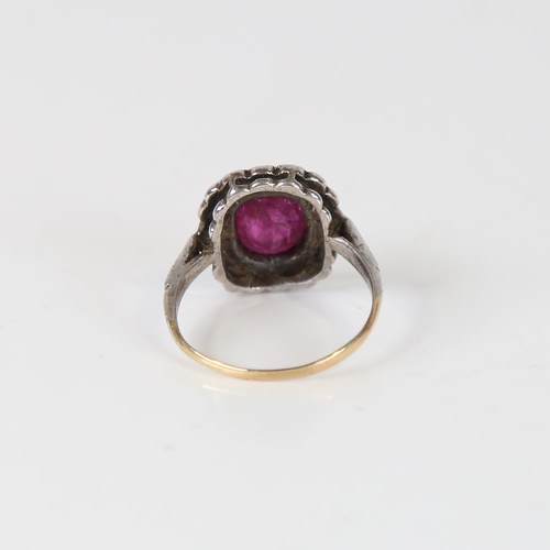 593 - A Vintage ruby and diamond cluster ring, unmarked gold and silver settings, with oval mixed-cut ruby... 