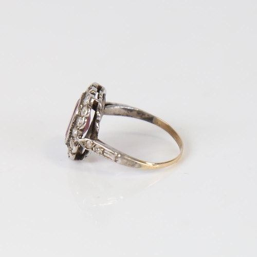 593 - A Vintage ruby and diamond cluster ring, unmarked gold and silver settings, with oval mixed-cut ruby... 