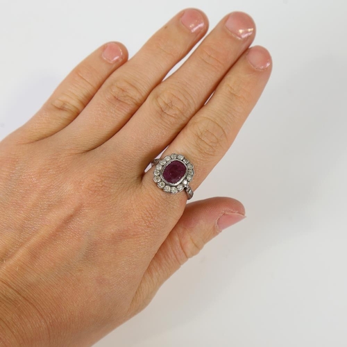 593 - A Vintage ruby and diamond cluster ring, unmarked gold and silver settings, with oval mixed-cut ruby... 