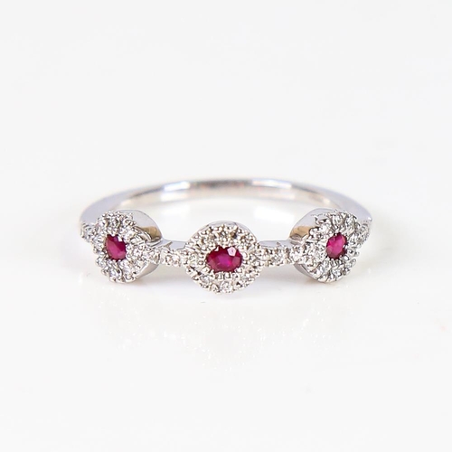 609 - A modern 18ct white gold ruby and diamond triple cluster dress ring, set with round-cut rubies and m... 