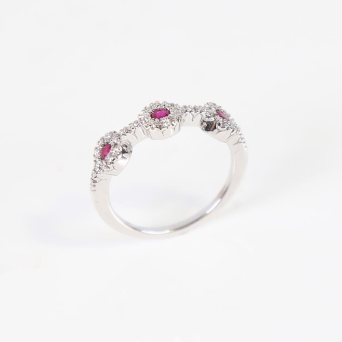 609 - A modern 18ct white gold ruby and diamond triple cluster dress ring, set with round-cut rubies and m... 