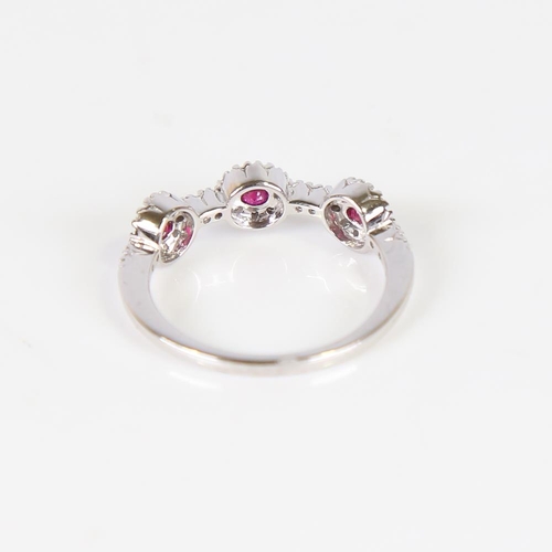 609 - A modern 18ct white gold ruby and diamond triple cluster dress ring, set with round-cut rubies and m... 