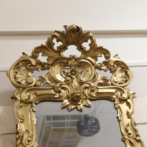 200 - A large relief carved giltwood-framed wall mirror, with elaborate pierced and scrolled pediment, hei... 