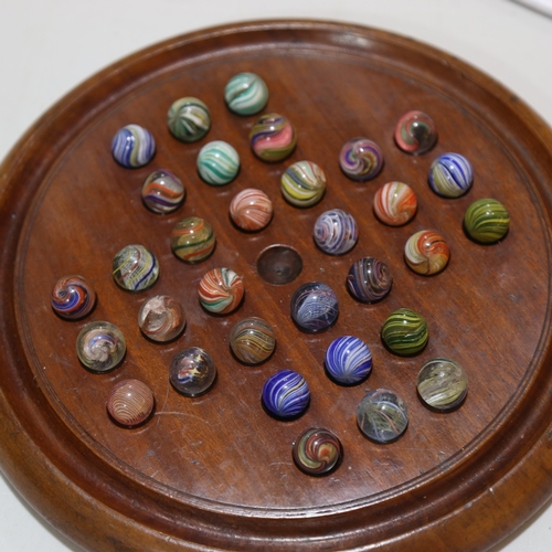 133 - A 19th century turned wood solitaire board and marbles, including onion skins, diameter 26cm