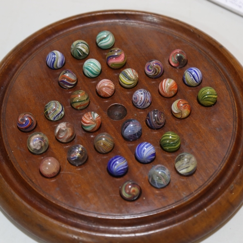 133 - A 19th century turned wood solitaire board and marbles, including onion skins, diameter 26cm