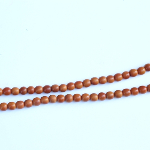 242 - A string of honey coloured natural horn beads, possibly rhino horn