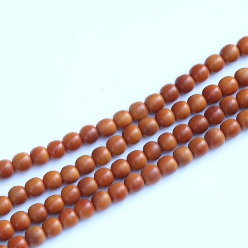 242 - A string of honey coloured natural horn beads, possibly rhino horn