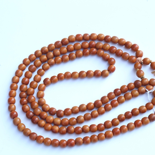 242 - A string of honey coloured natural horn beads, possibly rhino horn