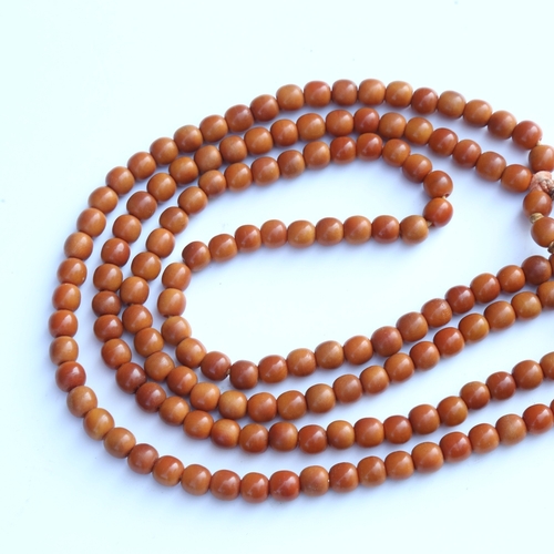 242 - A string of honey coloured natural horn beads, possibly rhino horn