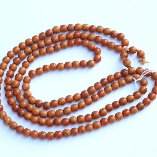 242 - A string of honey coloured natural horn beads, possibly rhino horn