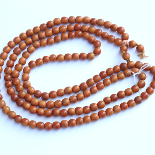 242 - A string of honey coloured natural horn beads, possibly rhino horn