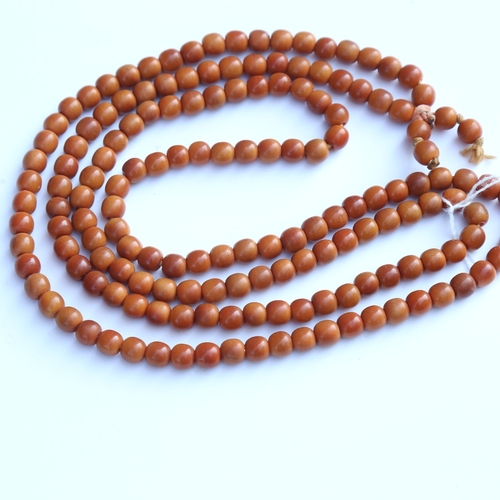 242 - A string of honey coloured natural horn beads, possibly rhino horn