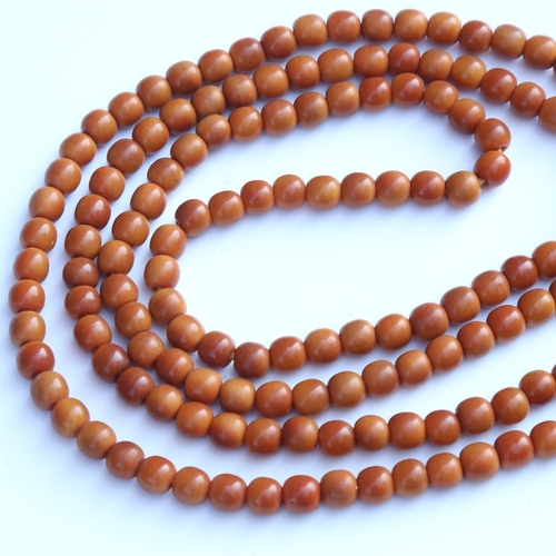 242 - A string of honey coloured natural horn beads, possibly rhino horn